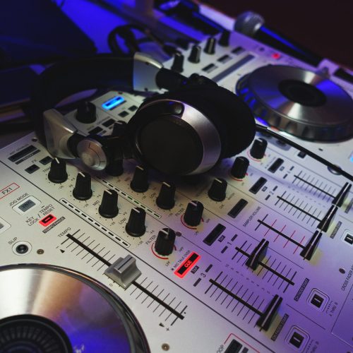 DJ mixer in bright colors disco in a nightclub.
